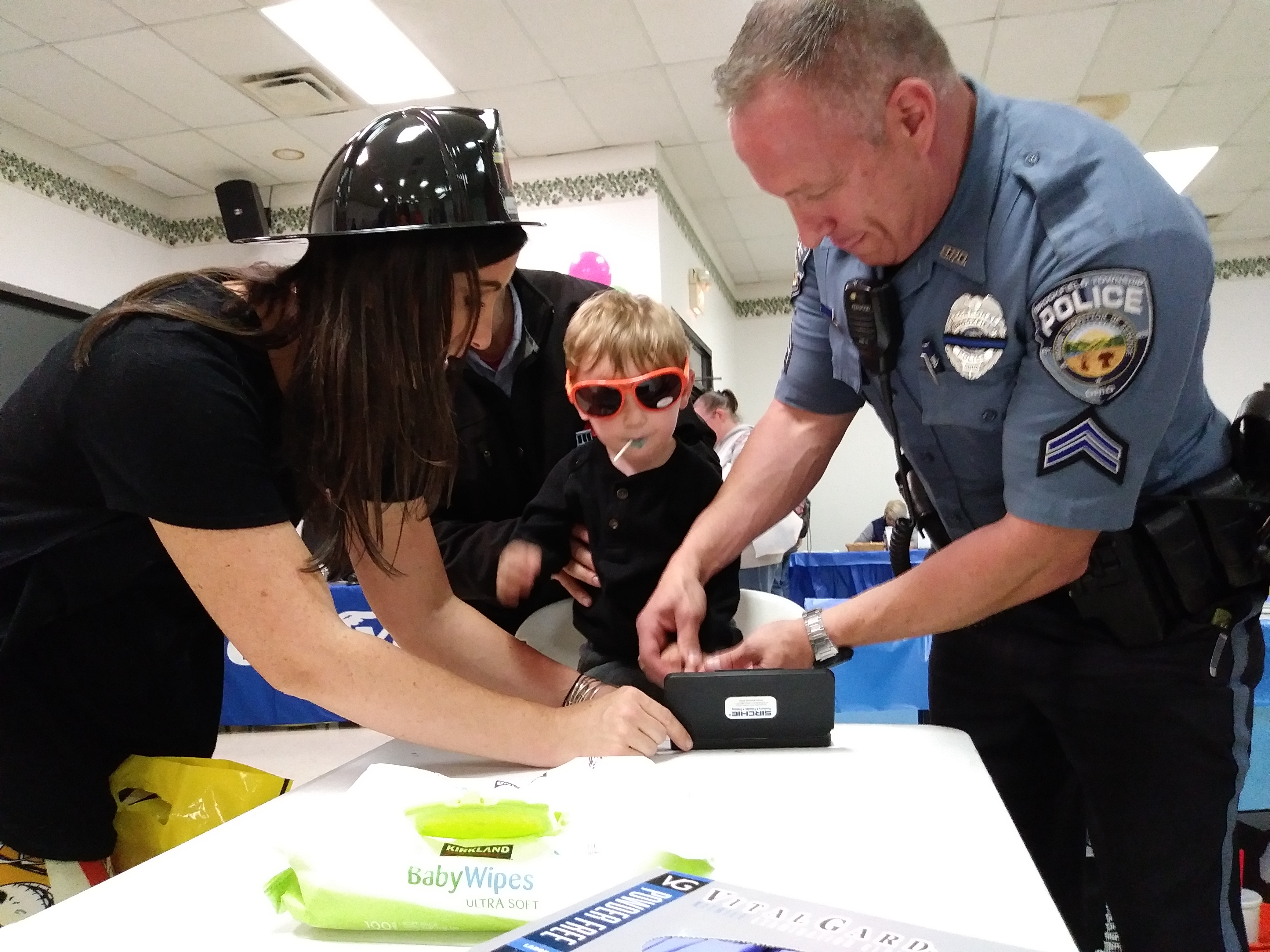 Brookfield police Cpl. Scott Thompson takes Reed Rooks' fingerprint at Safety Night in 2017. Reed's mother, Ashley, helps out.
