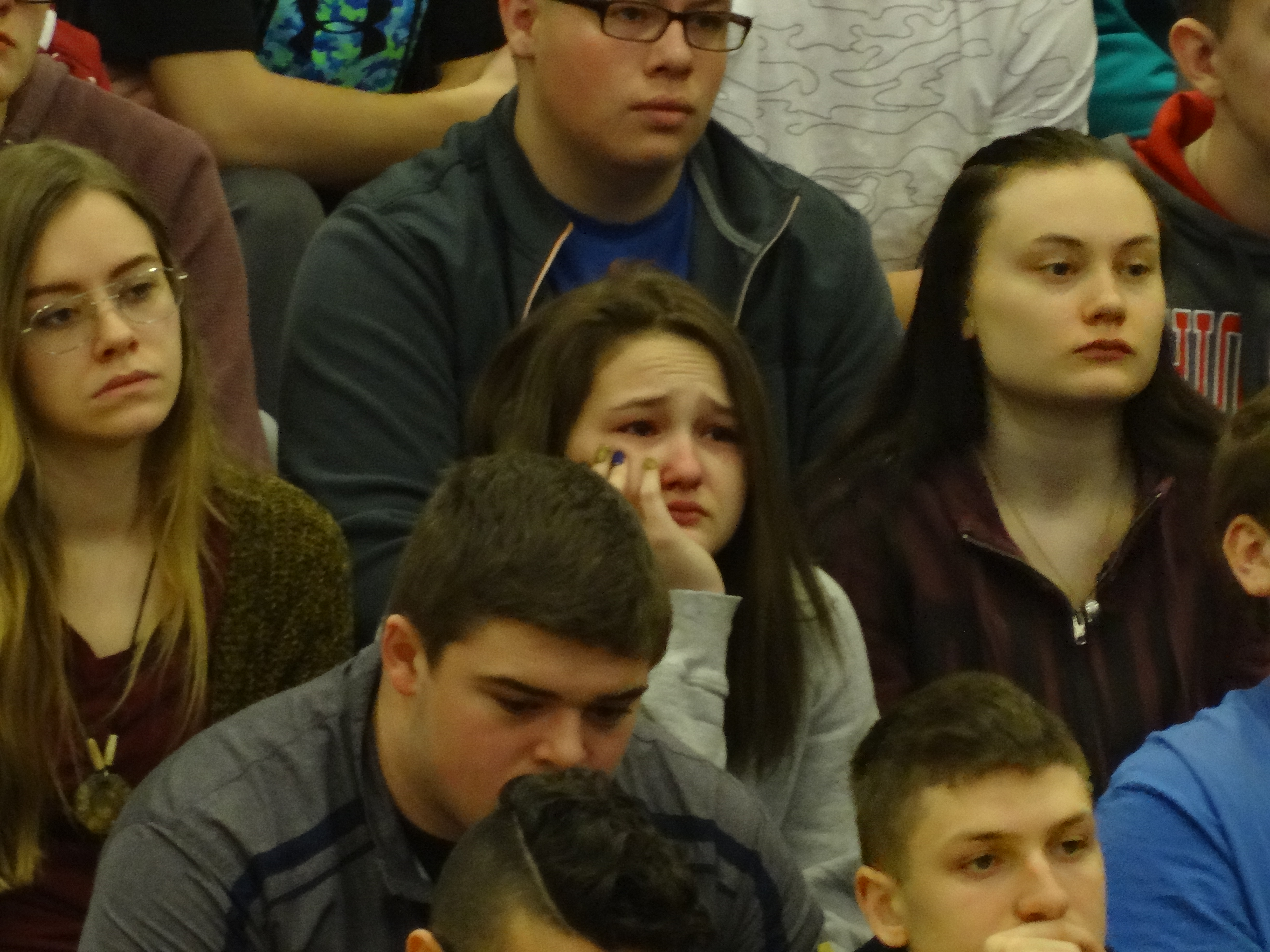 A student reacts to the reading of the names during Brookfield High School's National Walkout Day program.