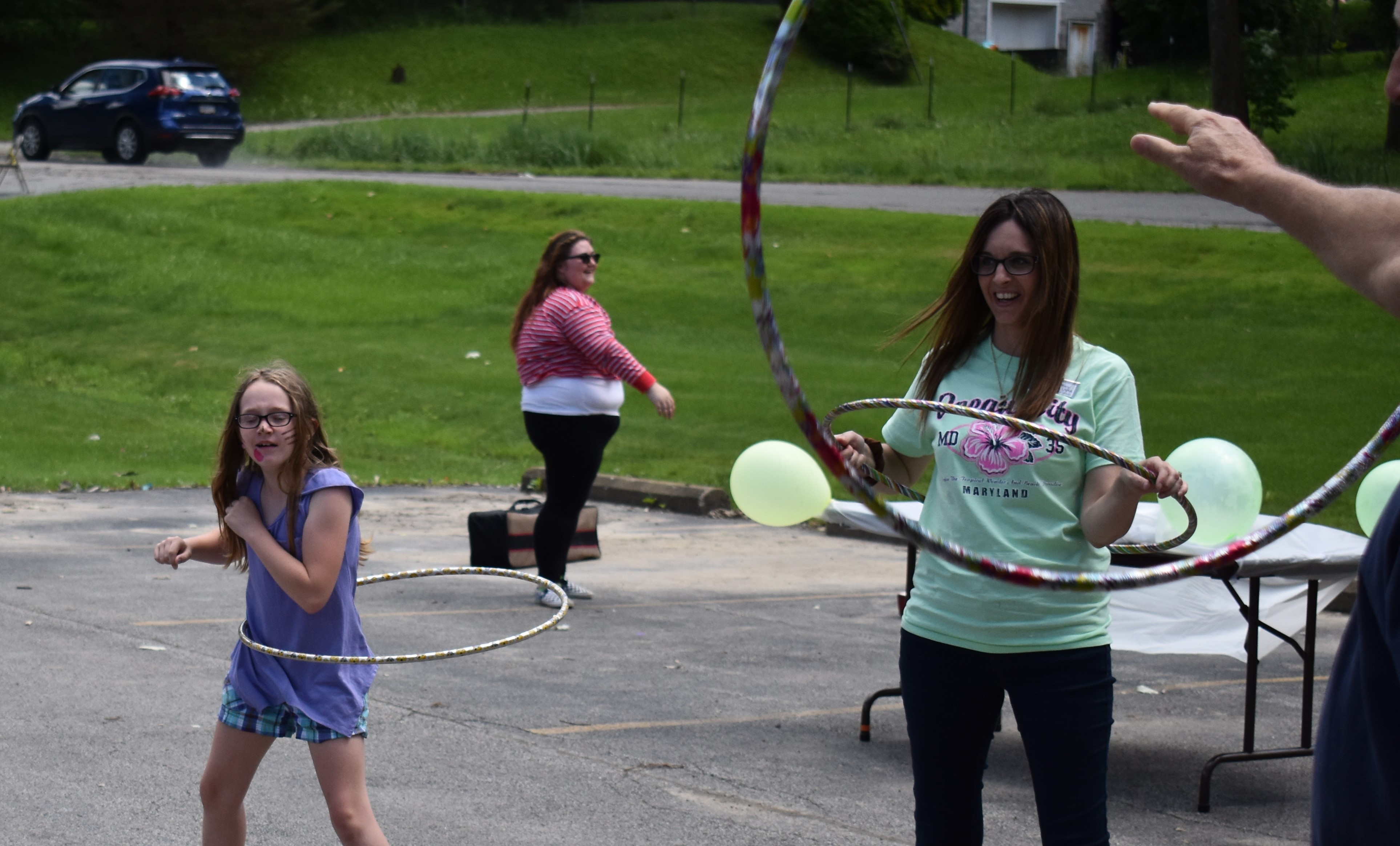 Amber Morrison, 9, gives the hula hoop her all at Addison Summer Fest. Addison Administrator Tiffany Lott is at right.