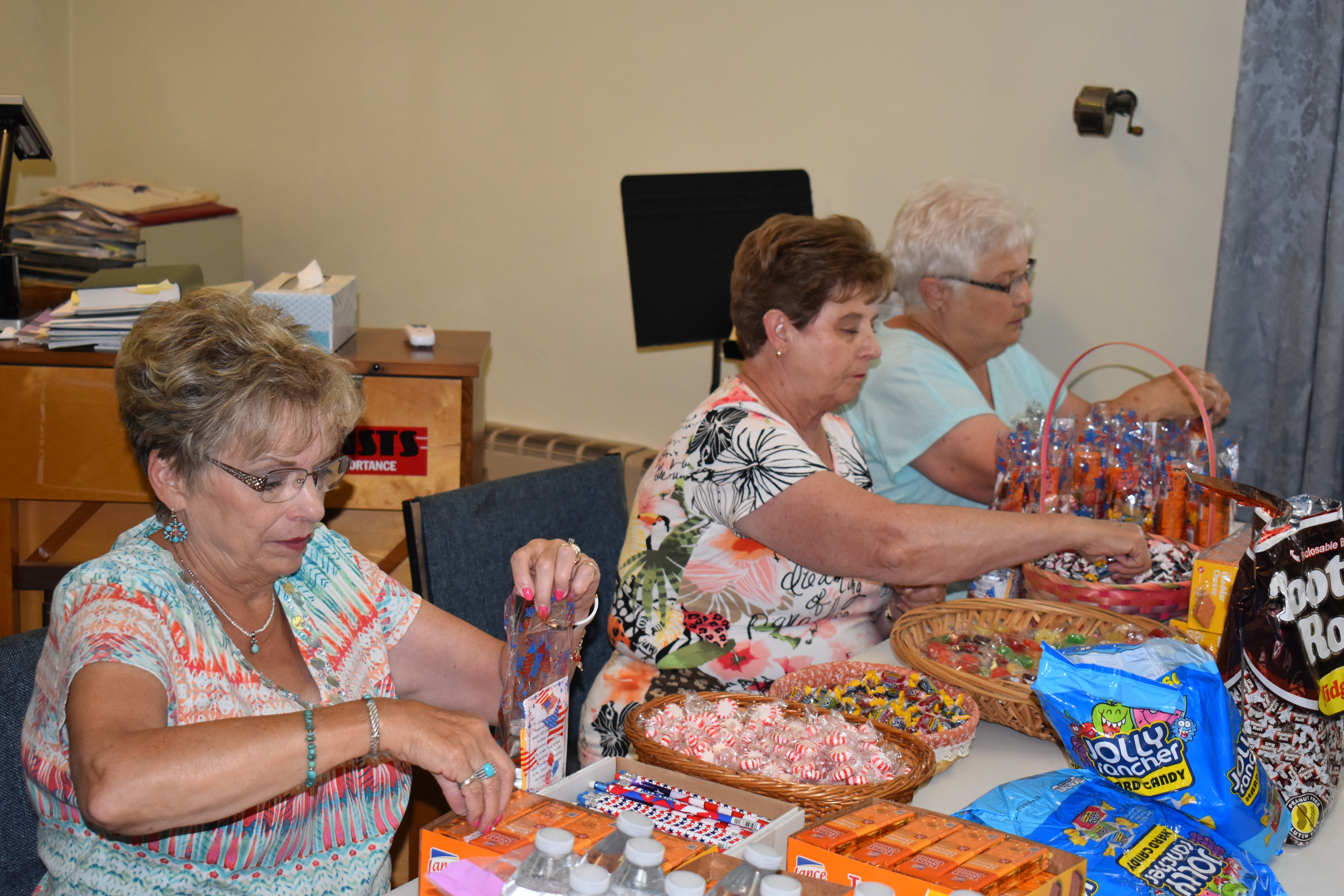 Summer Fest volunteers, from left, Diane Bullick, Elaine Obermiyer and Esther Medved stuff goody bags that will be handed out to active military personnel and veterans at Brookfield Summer Fest. The event, set for Aug. 10 and 11, will honor those who have served in the military.