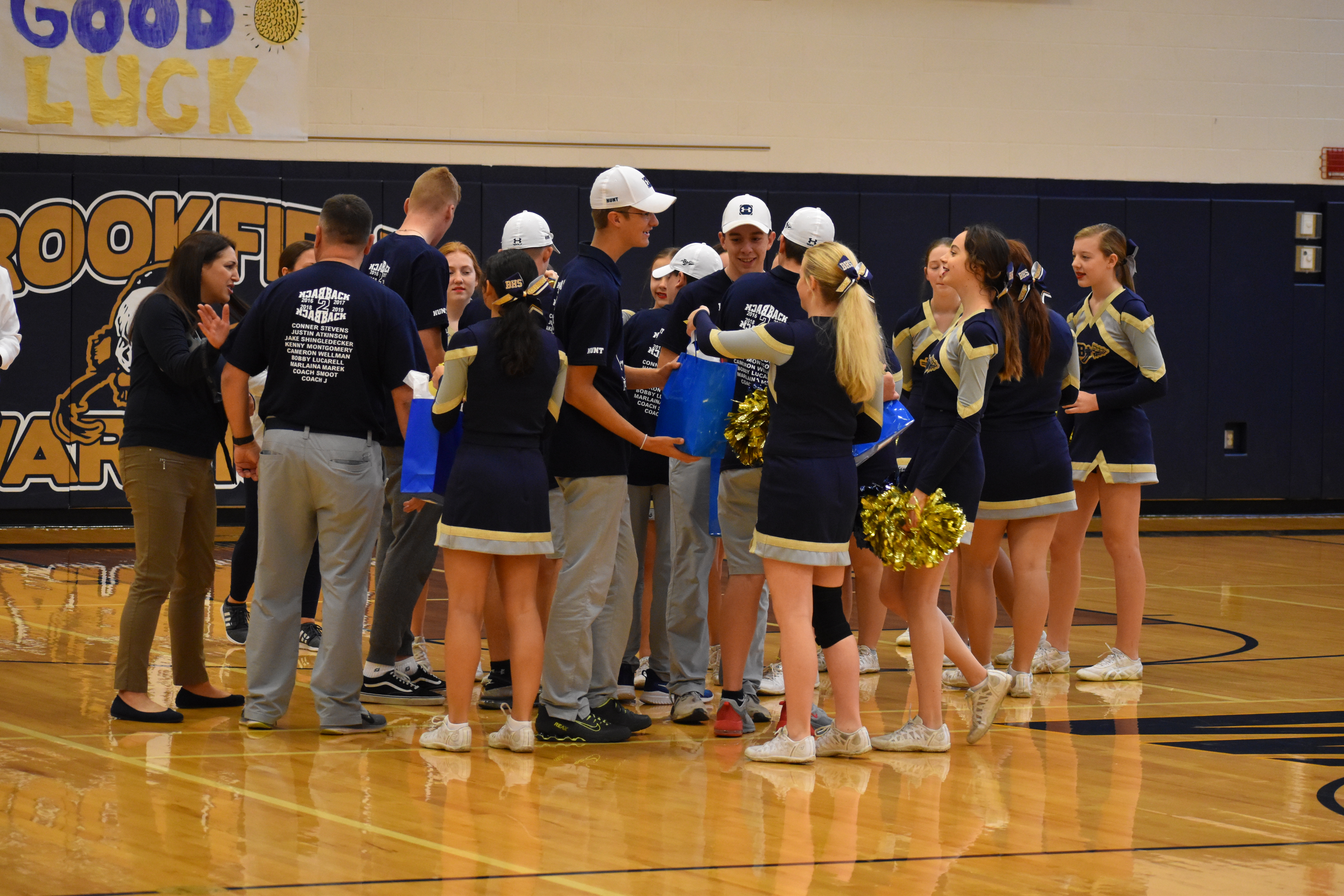 Cheerleaders pass out goodie bags to the golf team members.