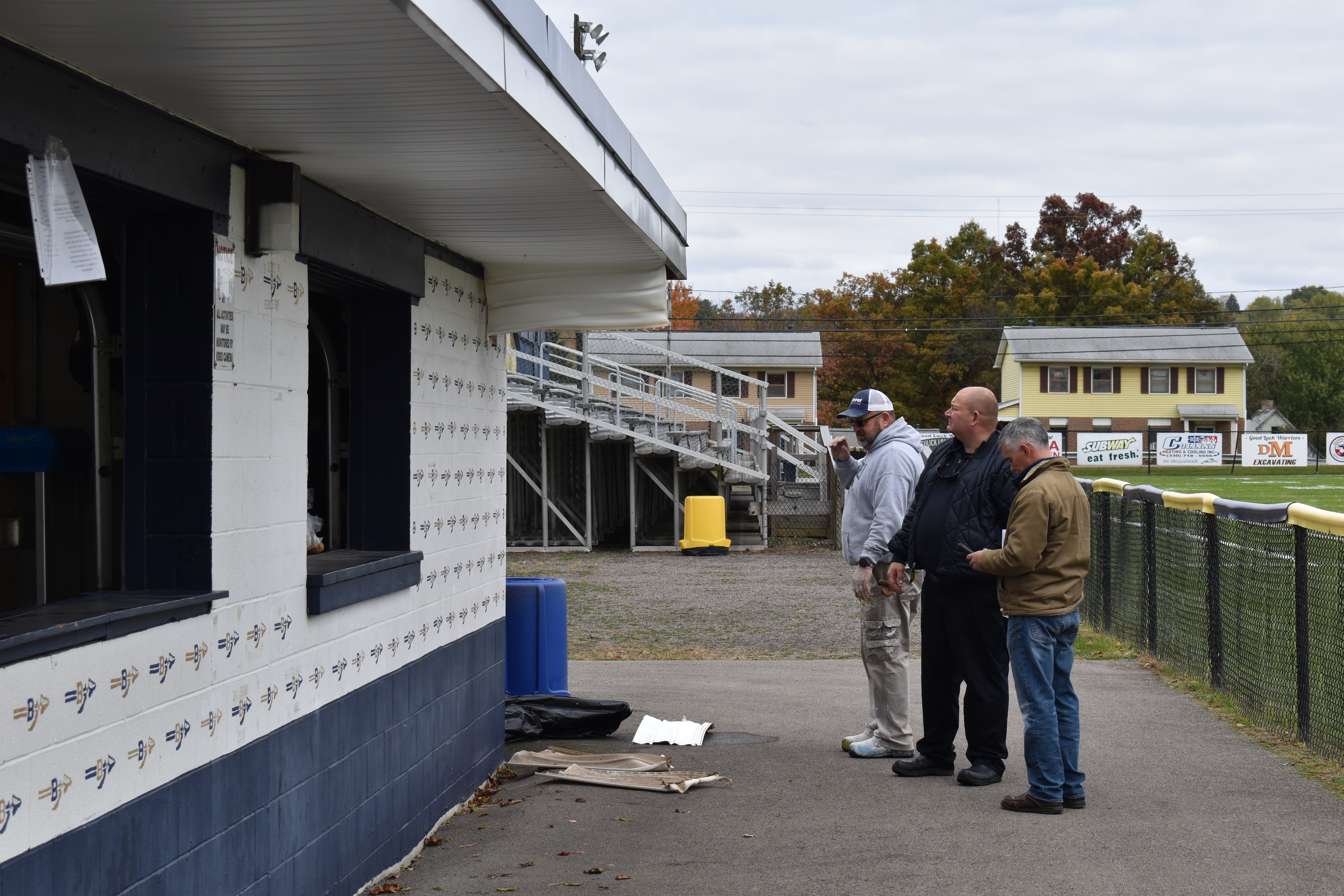 Brookfield school Maintenance Supervisor Randy Clark, left, and Supt. Toby Gibson, right, confer with Brookfield Fire Chief David Masirovits, who was investigating a fire at the football field concession stand.