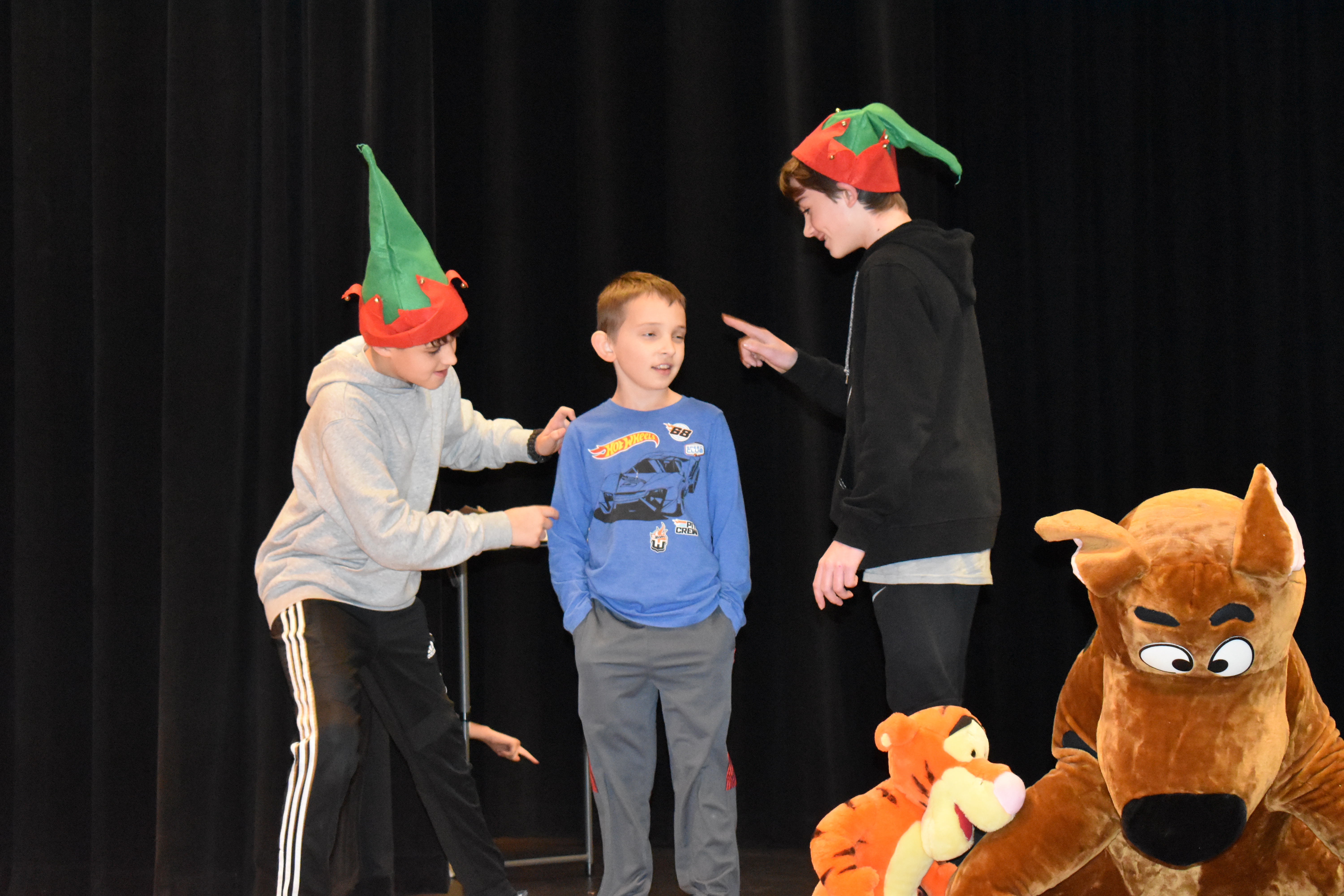 Sneaky Elf (played by Connor Mihalcin), and Stingy Elf (Will Cleland) try to activate Mechanical Toy (Jayden Caldwell).