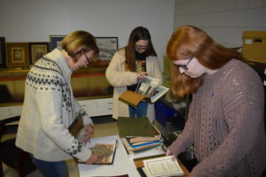 Barbar Stevens from the Brookfield Historical Society, left, Sarah Moell from the Trumbull County Historical Society, center, and AmeriCorps volunteer Olivia Beebe go through the holdings of the Brookfield society as part of an effort to post 500 photos online.