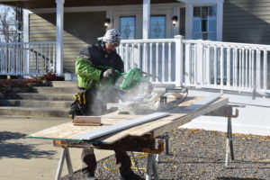 Jim Smith of ARMS Construction Group, Brookfield, cuts cement boards that were used to side the Briceland Funeral Services building in Brookfield Center.