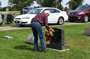 Lloyd Eggleston of Broken Bow, Neb., places a wreath on the grave of his Army brother, Charles Dobbins of Masury.