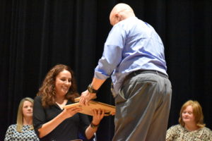 Kevin Boyd hands to Jolia Georges the plaque and other material related to her father's induction into the Brookfield Warrior Hall of Fame. John Georges coached basketball from 1964-68.