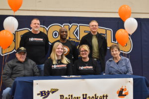 Bailey Hackett is shown with her mom, Tamie; her grandparents, Brian and Patty Hackett; her dad, Larry; brother, Joe; and Lourdes University wrestling coach Dock Kelly.