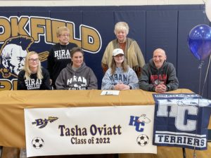 Brookfield High School senior, Tasha Oviatt (center, hat) smiles with her family after signing her National Letter of Intent to play soccer at Hiram College on March 4, 2022. From left to right: sister Taylor, grandma Janet Biro, mom Stacie, Tasha, Aunt Jerry Thornsberry, and father Frank. Contributed photo.