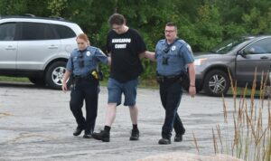 Brookfield police officers Krysta Wedge and Nicholas Leonardo escort Charles O'Connor to the police booking area.