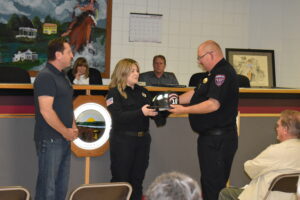 Carly Jackson, Brookfield's first female, full-time firefighter, is presented her helmet by Chief David Masirovits.