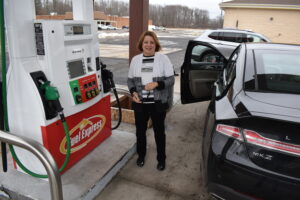 Debbie Dillon stands outside her car after fueling up at the newly reopened Fuel Express gas station and convenience store in Brookfield.
