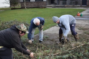 Kate Ross. left, and John Koosh, center, pull on branches being cut by Billy Bauder. The trio and Kate's husband, Doug, cut up two trees that were blown over on a neighbor's property.