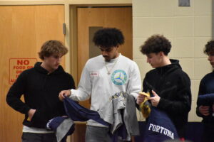 Brookfield High School basketball players, from left, Donovan Pawlowski, Isaiah Jones and Matteo Fortuna check out their conference championship T-shirts.