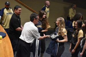 Katie Logan shakes the hand of Matt Gordon, in white shirt, to thank him for the jackets the Brookfield Fallen Firefighters Foundation donated to the Brookfield High School softball team.