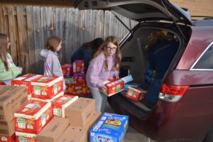 Members of Girl Scout Troop 80266, which has members from Brookfield and Hubbard, unpacks a minivan full of food for the Brookfield Backpack Charitable Foundation.