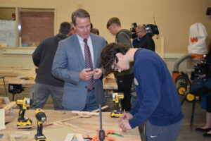 Ohio Lt. Gov. Jon Husted chats with junior Brett Carsone during a tour of Brookfield schools. Carsone was working on a project in the pre-apprenticeship shop.
