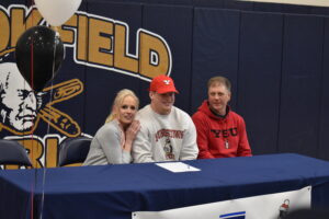 Brookfield High School senior Ryan Tetrick is shown with his parents, Patti and David, after he has signed his letter of intent to pursue track and field events at Youngstown State University. Ryan hold the school's records in throwing events.