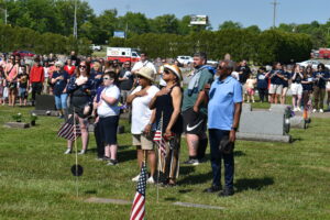 Members of the Phillips-Walker family, foreground and others salute the flag as the Brookfield High School band plays “The National Anthem” at Brookfield's Memorial Day observance.