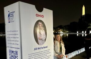 Jill McFarland stands next to a placard of herself that was posted on the National Mall for Lights of Hope. Contributed photo.