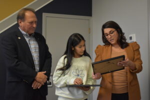 Mark Ferrara and Shannon Devitz present Jenna Omar a certificate on behalf of the fire chief.