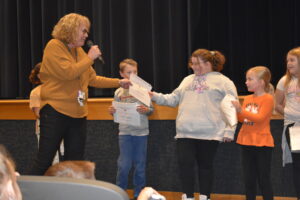 Brookfield Elementary School secretary Barb Simon hands a certificate to Cassie Harris for reading the most minutes during the Read-A-Thon, 2,285 over a two-week period,