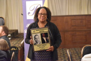 Carmen Ledbetter holds the plaque honoring her father, Clyde, at the Brookfield Distinguished Alumni Hall of Fame banquet.