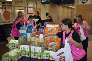 Middle school girls basketball players fill food bags that will be handed out to elementary students, a program run by the Brookfield Backpack Charitable Foundation.