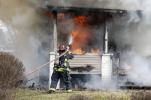 Brookfield Fire Capt. Steve Smoot attacks a fire at 775 Brookfield Ave. in Masury. Photo by Gerard Zarella.