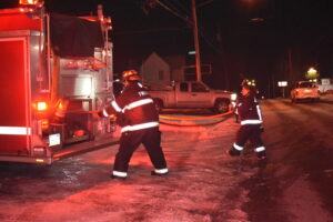 Firefighters from Sharon and Brookfield pull hose off a Sharon truck to fight a fire at Hilltop Pizza in Masury.