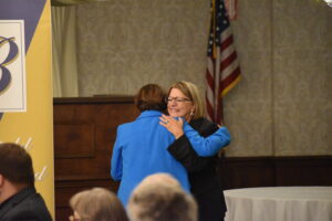 Deborah Vasbinder Dillon, right, is embraced by her sister, Darlene Vasbinder-Calhoun, at their induction into the Brookfield Distinguished Alumni Hall of Fame.