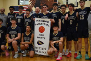 Matteo Fortuna celebrates scoring 1,000 points in his basketball career with his coaches and teammates on Feb.